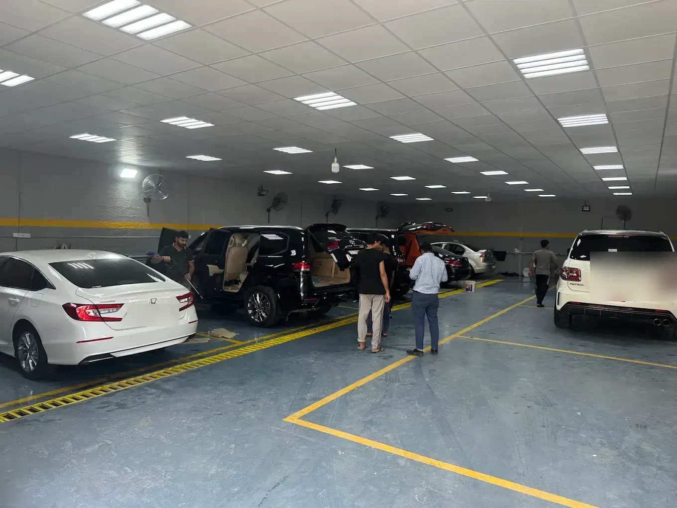Workshop bay with multiple vehicles being serviced at Madeena Al Amwaj Auto Workshop